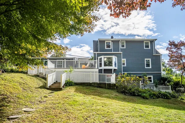 a white house that has a tree in front of it