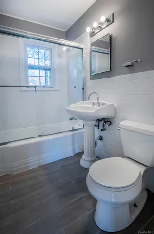 a bathroom with a toilet a sink and mirror