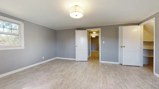 an empty room with closet and windows