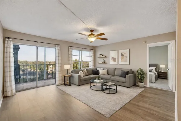 a living room with furniture and a large window with balcony view