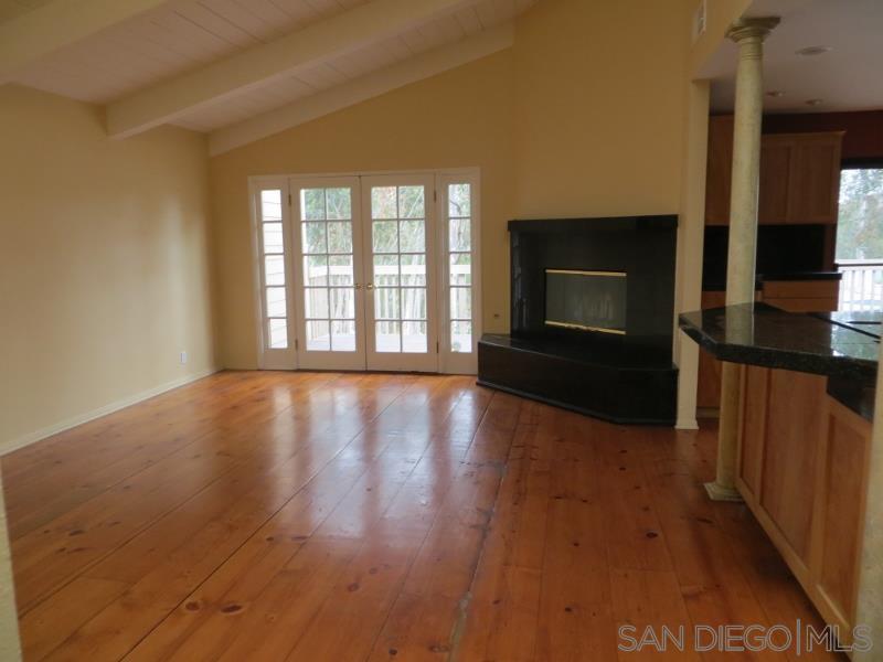 a view of wooden floor fire place and windows in a room