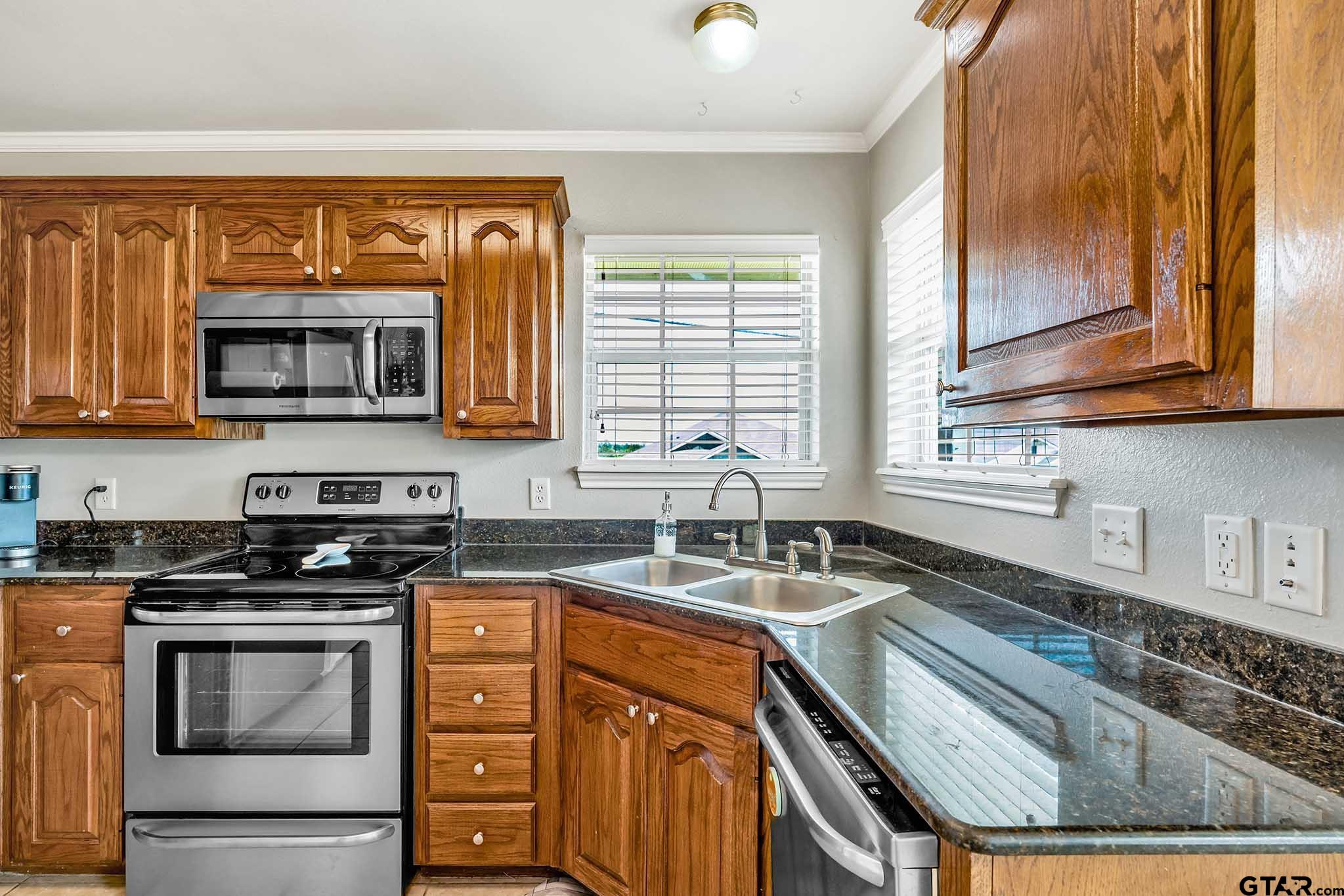 101 Collin Drive Chandler, TX 75758 - Photo 7 of 24 a kitchen with granite countertop a sink stove top oven and microwave