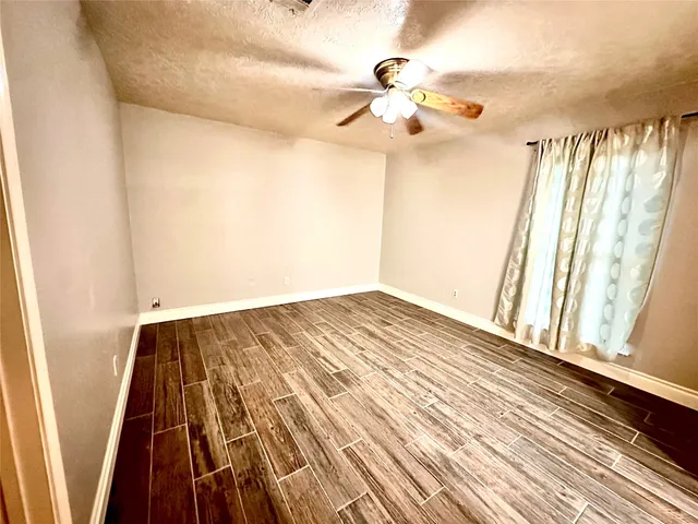 a view of a room with wooden floor and fan