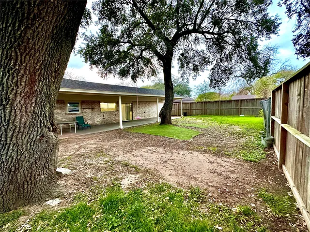 a view of a house with backyard and tree