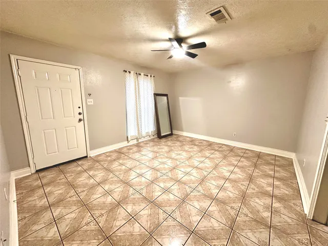 a view of a livingroom with wooden floor and a chandelier fan
