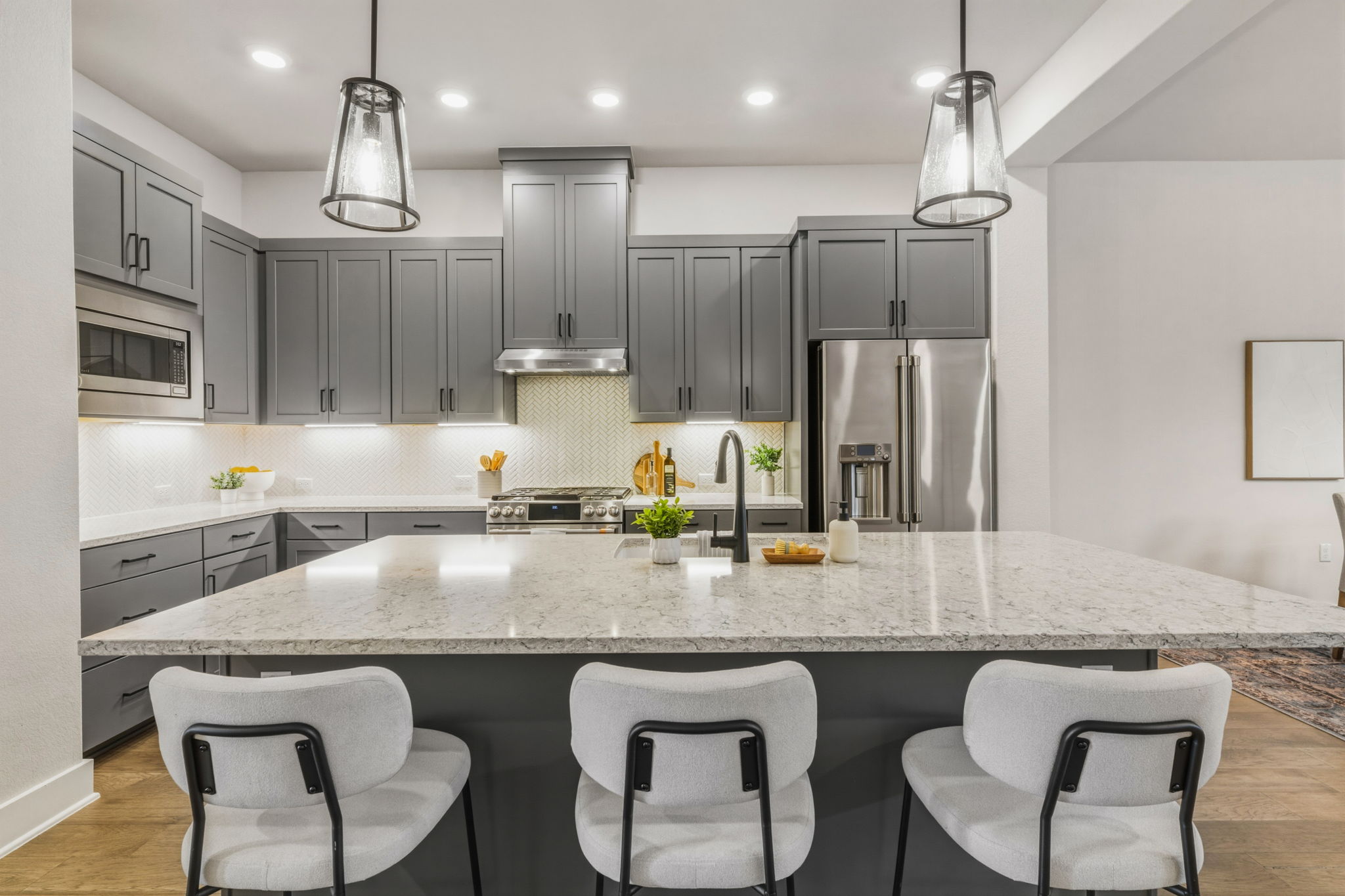 2929 Moreno Street Austin, TX 78723 - Photo 11 of 40 Spacious kitchen featuring an expansive island with a light-toned countertop, gray shaker-style cabinetry, and stainless steel appliances