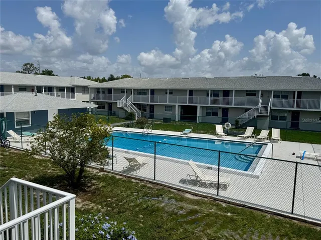 a view of a house with swimming pool and sitting area