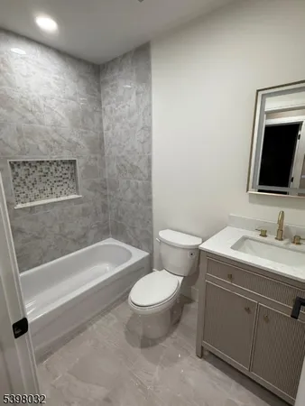 a bathroom with a granite countertop toilet a sink and bathtub
