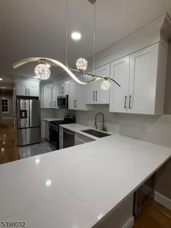 a kitchen with stainless steel appliances a sink a stove and a refrigerator