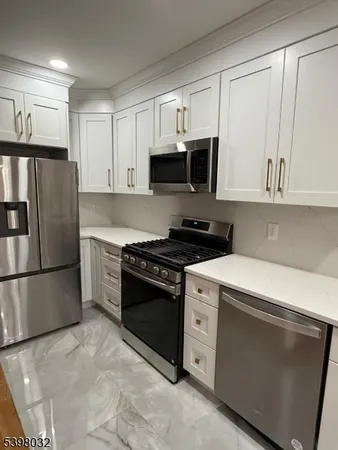 a kitchen with stainless steel appliances granite countertop a stove a refrigerator and a microwave