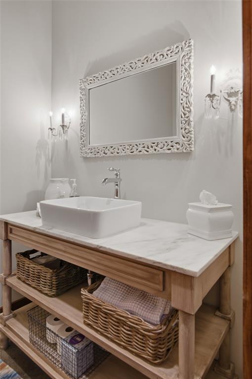 1138 Bancroft Road Keller, TX 76248 - Photo 27 of 39 Floating vessel sink with chrome faucet, set on a natural wood vanity with a stone countertop