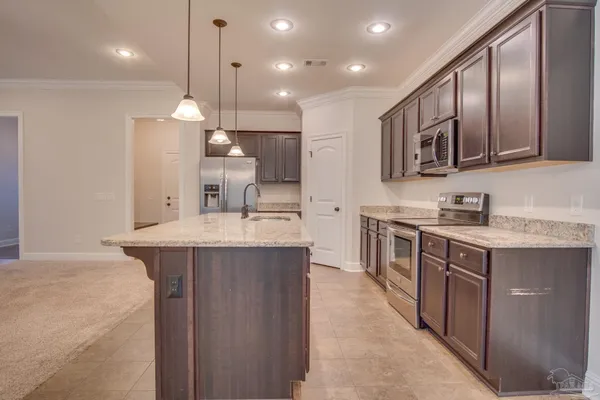 a kitchen with stainless steel appliances granite countertop a sink a stove and a refrigerator