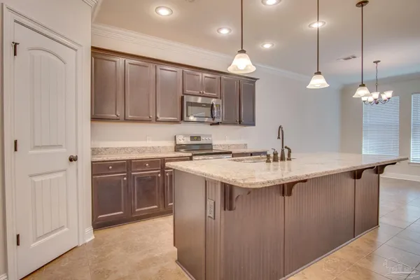 a kitchen with stainless steel appliances granite countertop a sink a kitchen island a stove and a wooden floors