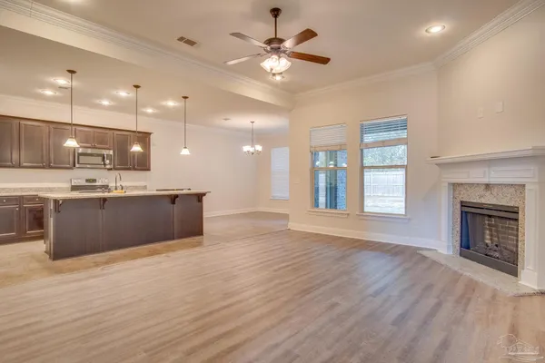 a large kitchen with kitchen island a stove a sink dishwasher and a fireplace