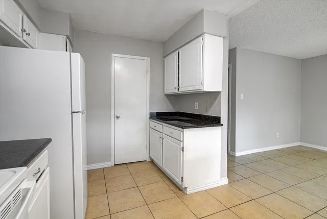 a kitchen with a refrigerator sink and cabinets