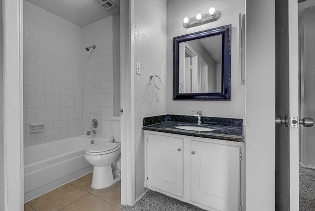 a bathroom with a granite countertop sink toilet and mirror