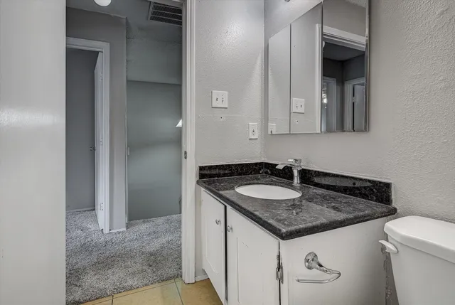 a bathroom with a granite countertop sink and a mirror