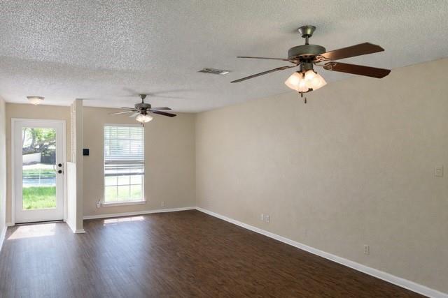 6009 Deborah Lane Watauga, TX 76148 - Photo 4 of 13 an empty room with wooden floor fan and windows