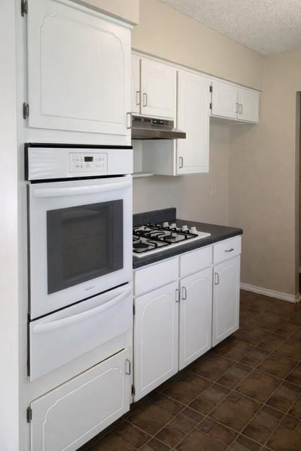 6009 Deborah Lane Watauga, TX 76148 - Photo 5 of 13 a kitchen with white cabinets and white appliances