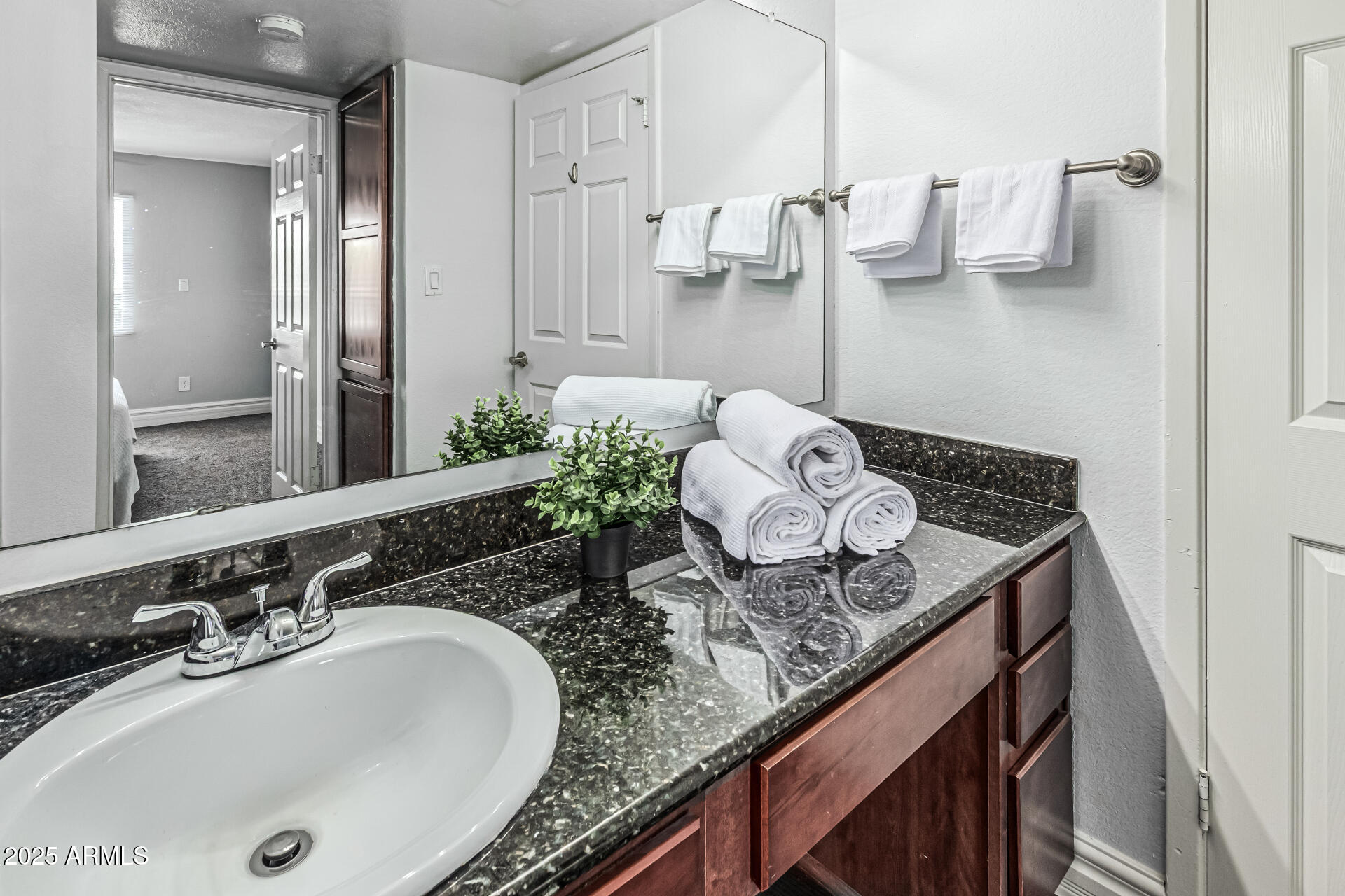 3825 East Camelback Road, Unit 152 Phoenix, AZ 85018 - Photo 11 of 28 a bathroom with a granite countertop sink and a mirror