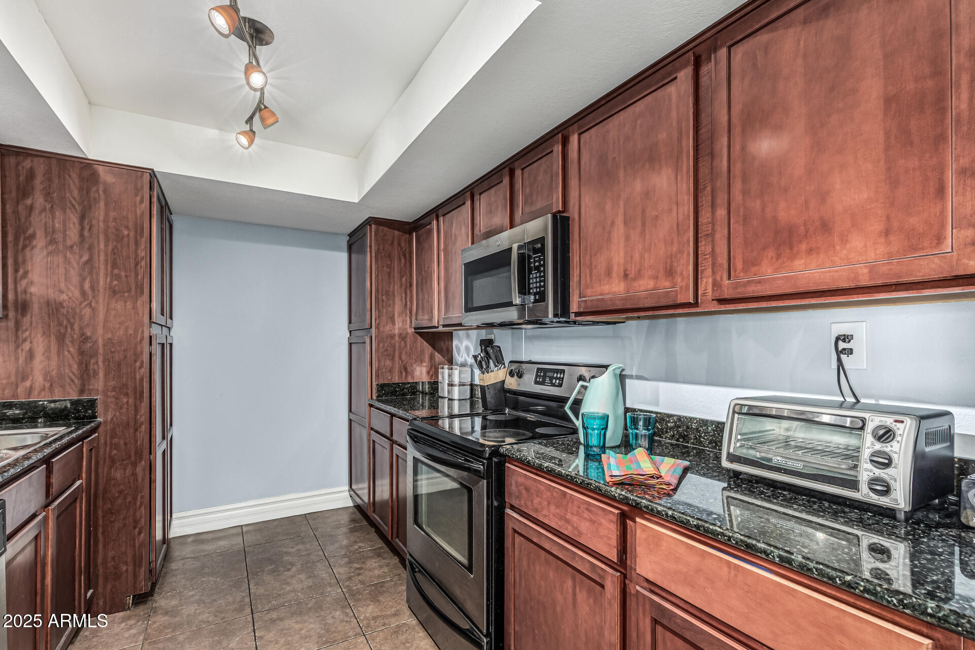 3825 East Camelback Road, Unit 152 Phoenix, AZ 85018 - Photo 4 of 28 a kitchen with stainless steel appliances granite countertop a stove and a microwave