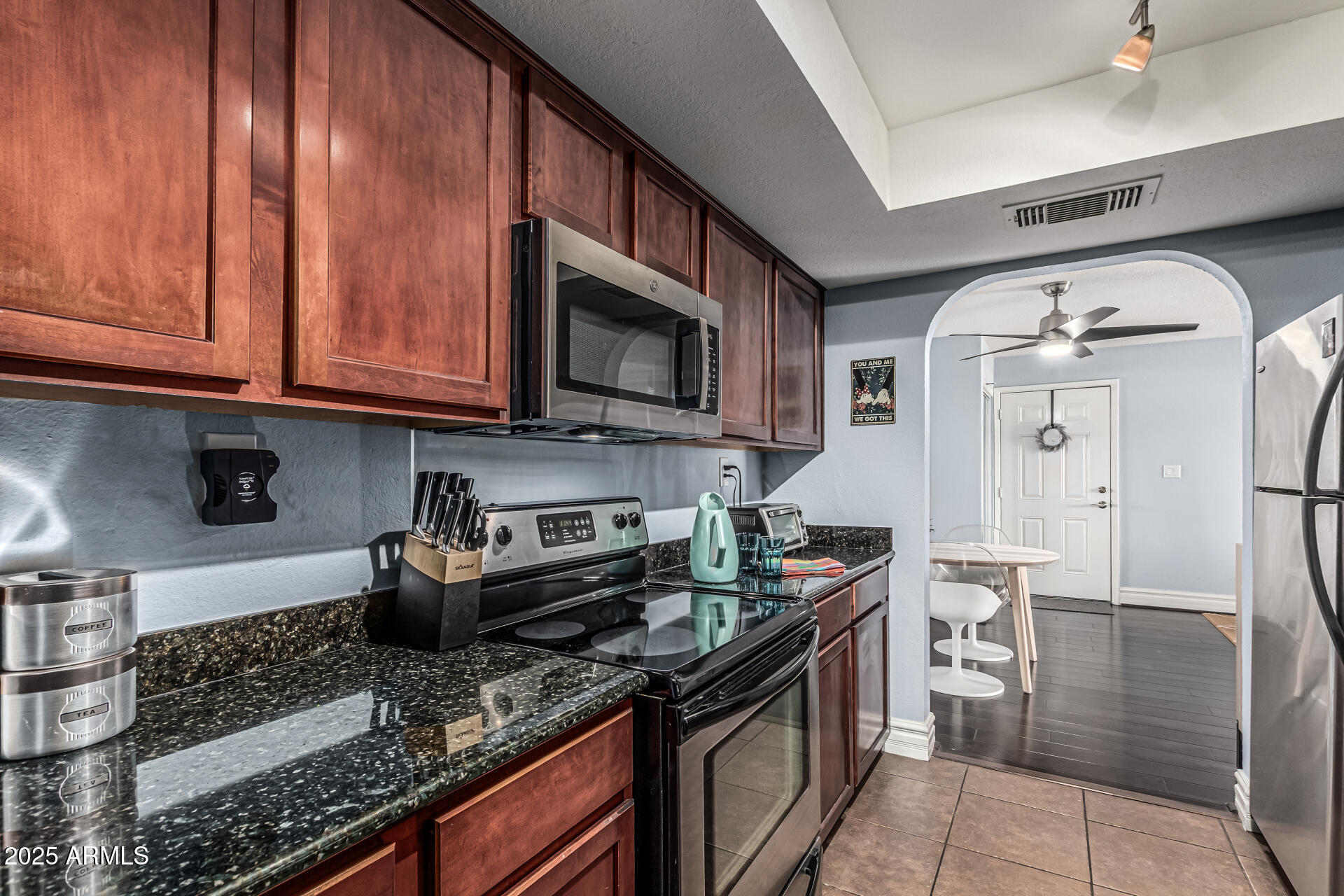 3825 East Camelback Road, Unit 152 Phoenix, AZ 85018 - Photo 7 of 28 a kitchen with stainless steel appliances granite countertop a stove a sink and a microwave