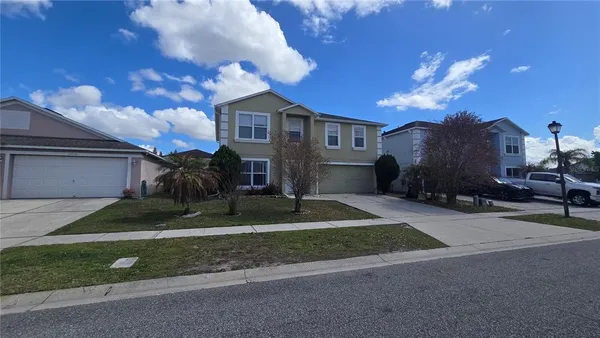 a front view of a house with a yard and a garage