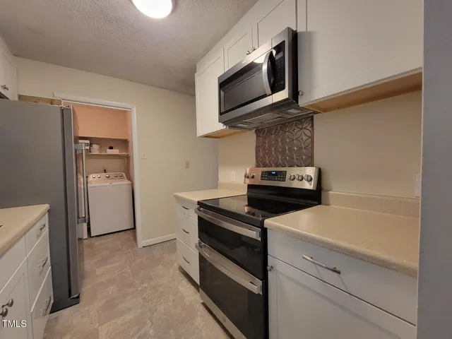 a kitchen with a refrigerator stove and microwave