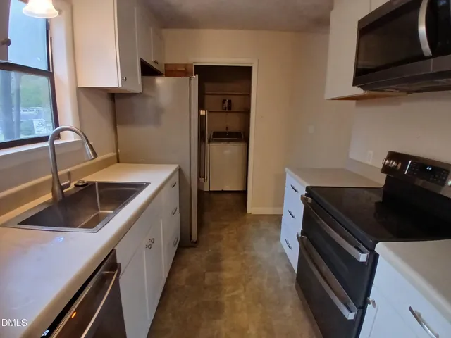 a kitchen with a sink stove and cabinets