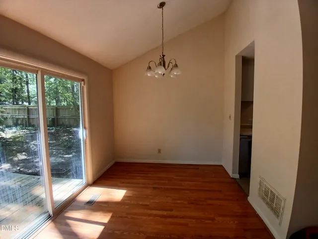 a view of a room with wooden floor and a window