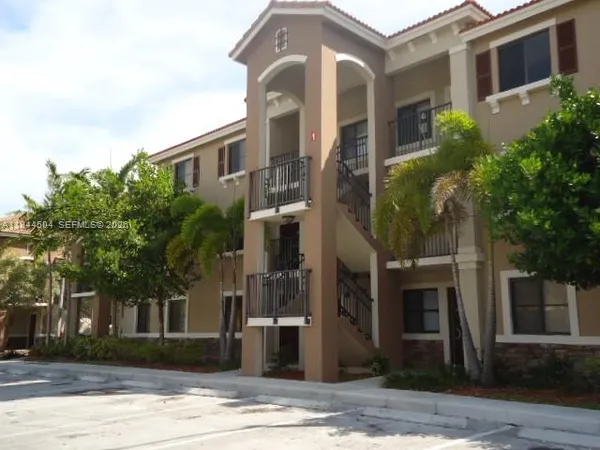 a front view of a building with a garden