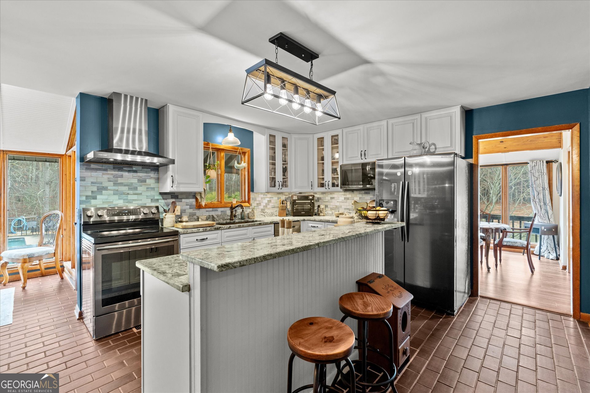 620 Smyrna Church Road Carrollton, GA 30117 - Photo 15 of 68 a kitchen with stainless steel appliances granite countertop a stove refrigerator a sink dishwasher and a dining table with wooden floor