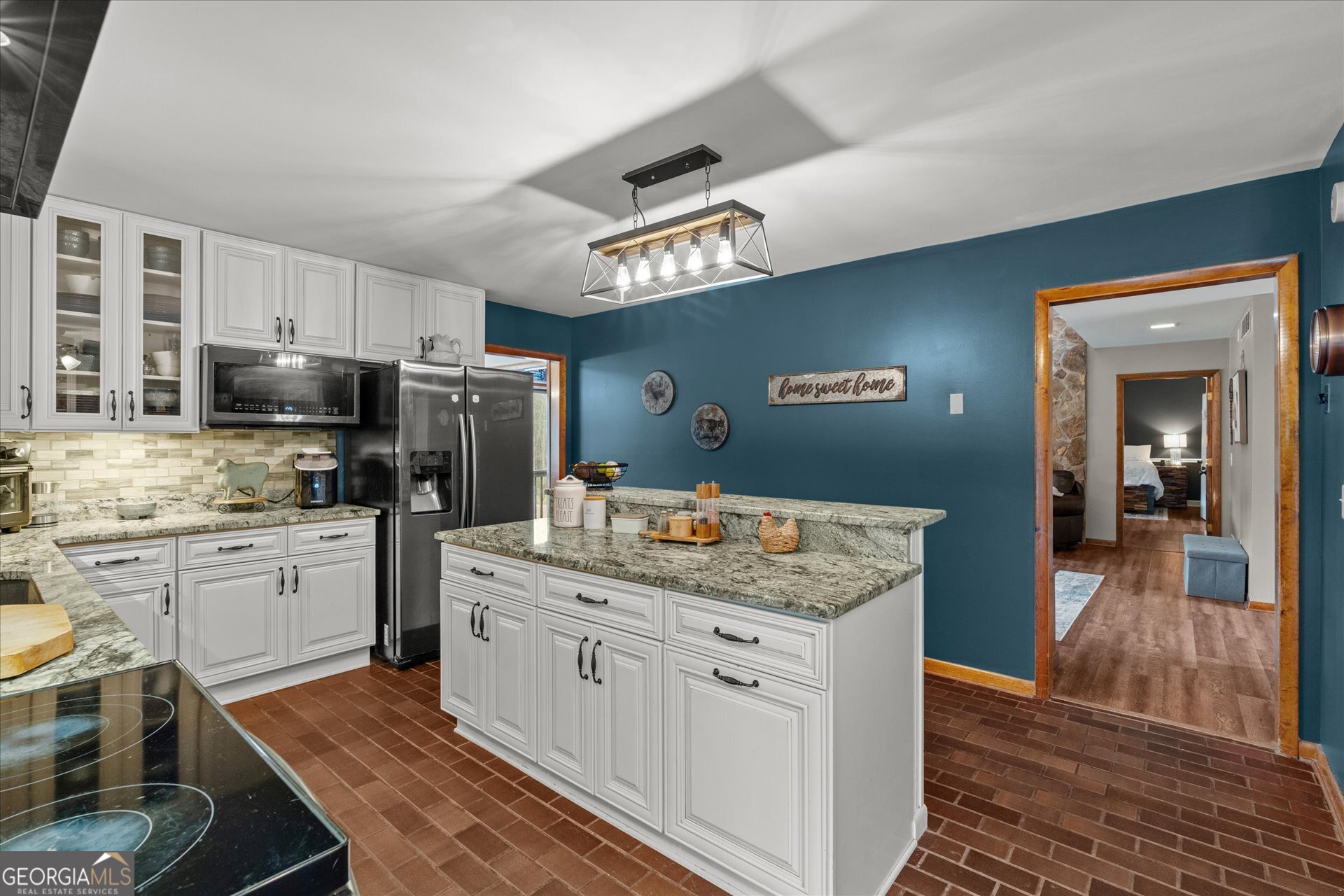 620 Smyrna Church Road Carrollton, GA 30117 - Photo 17 of 68 a kitchen with a sink dishwasher a stove a microwave oven and a dining table with wooden floor
