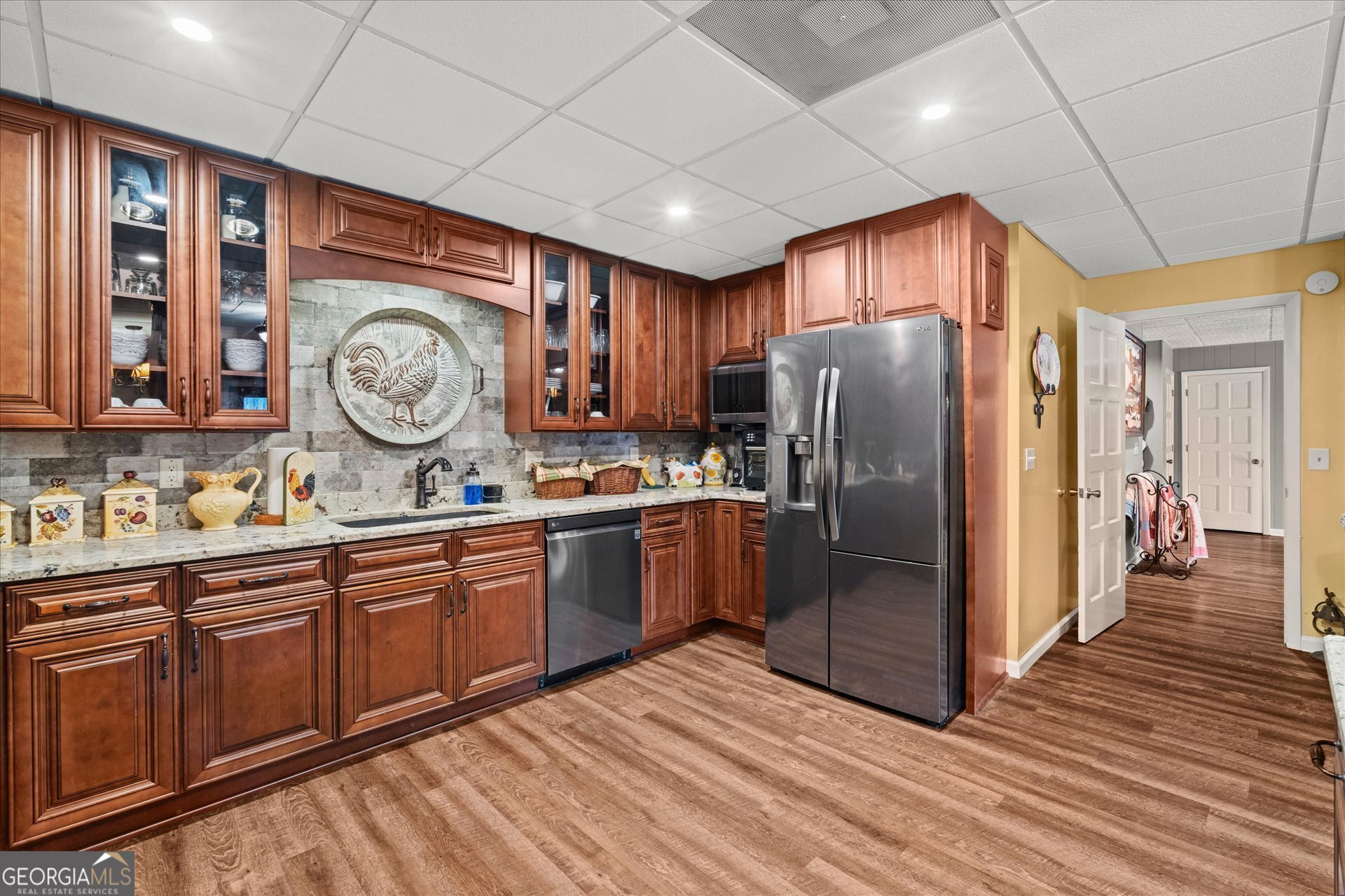 620 Smyrna Church Road Carrollton, GA 30117 - Photo 51 of 68 a kitchen with stainless steel appliances granite countertop a refrigerator a sink dishwasher a stove and white countertops with wooden floor