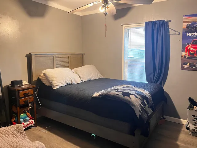 a bedroom with a bed and wooden floor