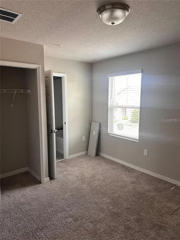 an empty room with windows and closet