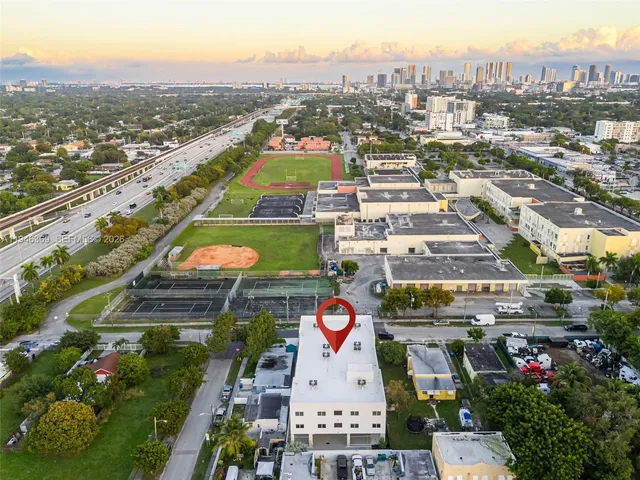 an aerial view of residential houses with outdoor space and trees