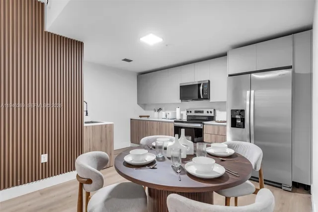 a dining room with furniture and kitchen view