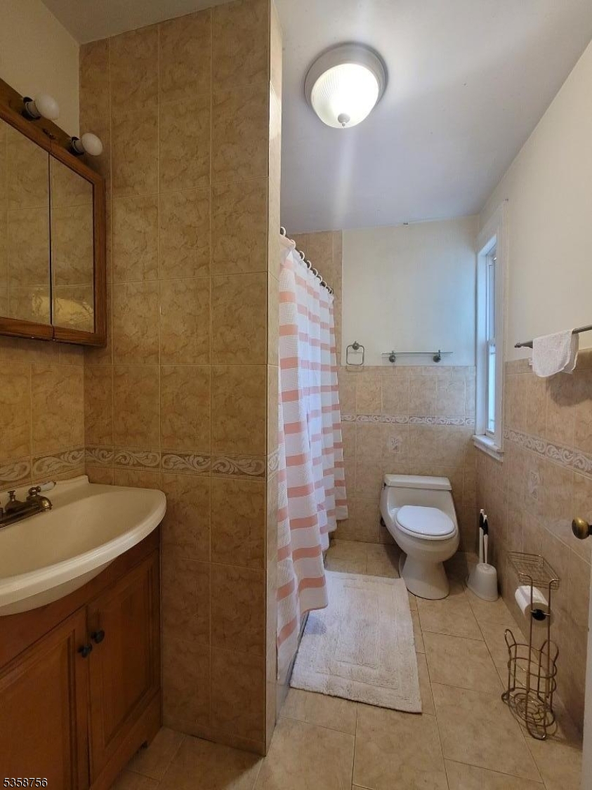 71 Montclair Avenue, Unit 2B Montclair, NJ 07042 - Photo 5 of 10 a bathroom with a toilet sink and mirror