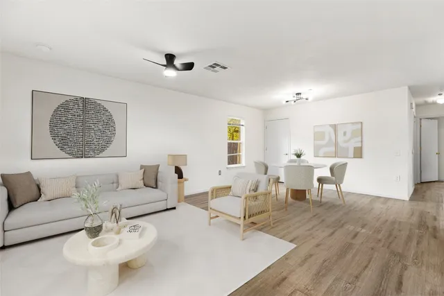 a living room with furniture and a wooden floor