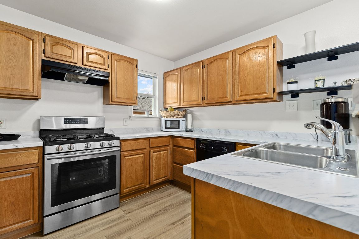 6110 Devonshire Cove Austin, TX 78723 - Photo 13 of 31 a kitchen with stainless steel appliances granite countertop a sink stove and cabinets