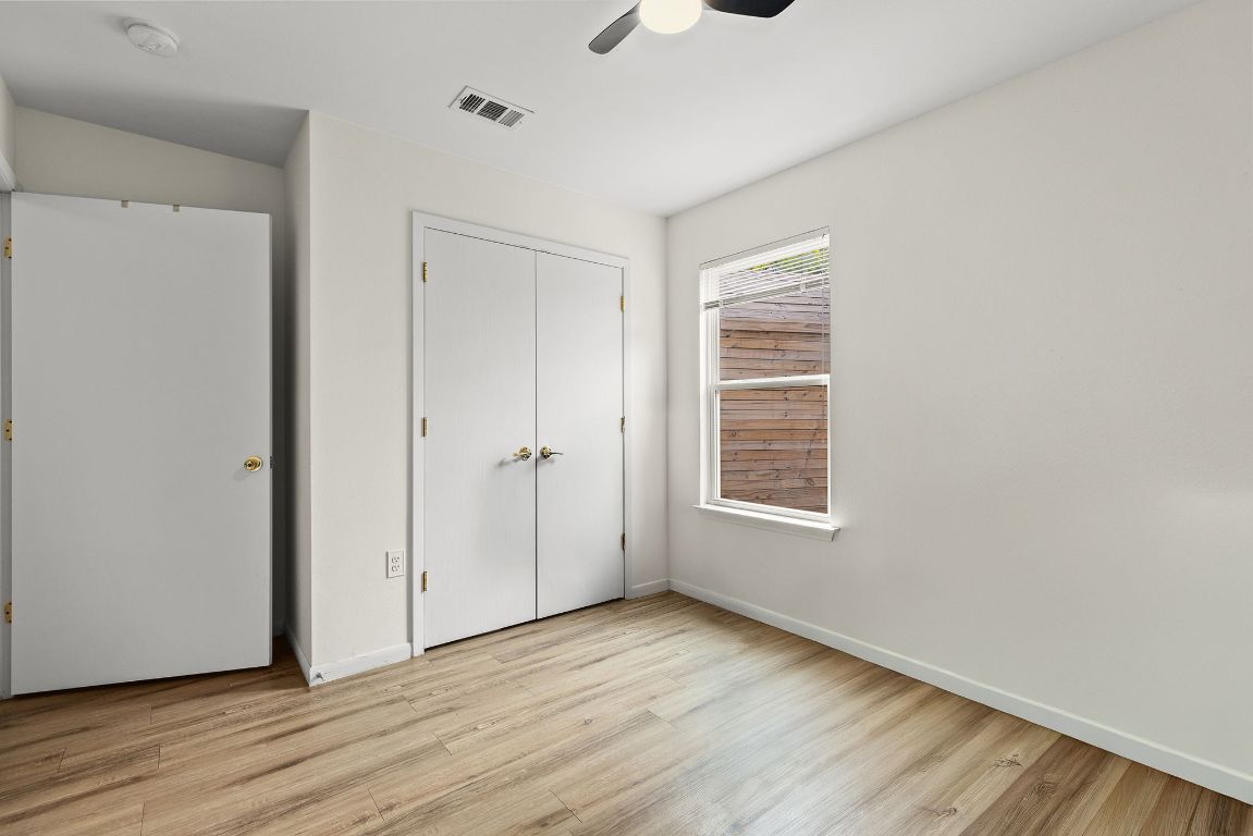 6110 Devonshire Cove Austin, TX 78723 - Photo 17 of 31 a view of an empty room with wooden floor and a window