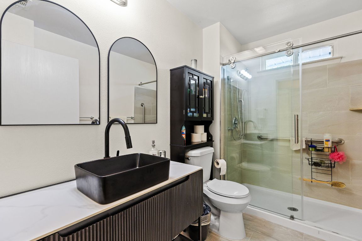 6110 Devonshire Cove Austin, TX 78723 - Photo 18 of 31 a bathroom with a sink a toilet and shower