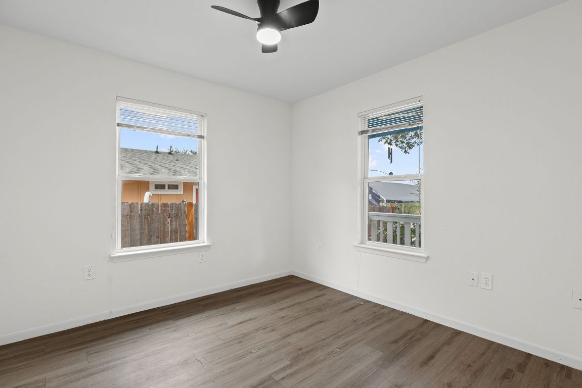 6110 Devonshire Cove Austin, TX 78723 - Photo 20 of 31 an empty room with wooden floor cabinet and windows