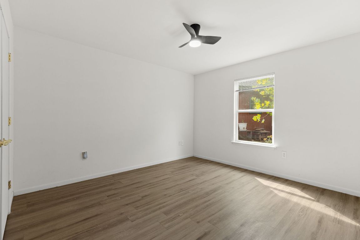 6110 Devonshire Cove Austin, TX 78723 - Photo 22 of 31 a view of an empty room with a window and wooden floor
