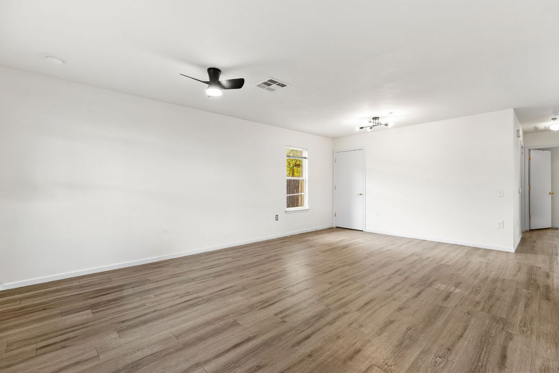6110 Devonshire Cove Austin, TX 78723 - Photo 9 of 31 an empty room with wooden floor and windows