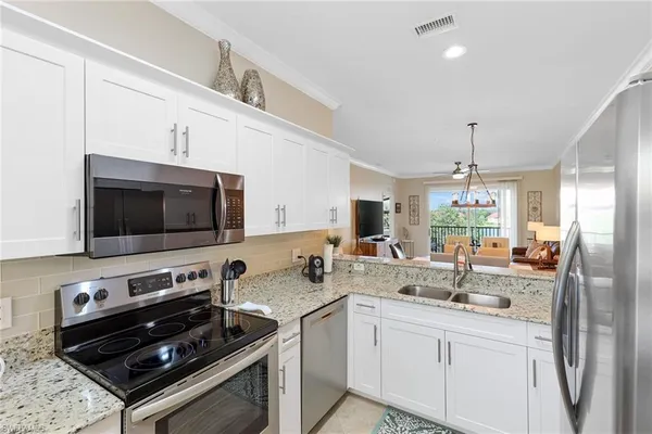 a kitchen with stainless steel appliances granite countertop a sink refrigerator and cabinets