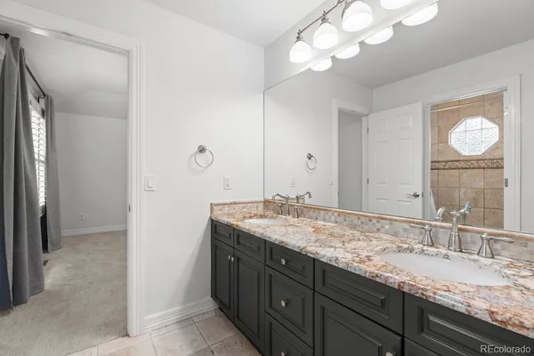 a bathroom with a granite countertop sink and a mirror