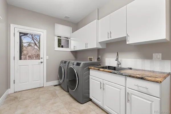 a kitchen with granite countertop a sink a stove and cabinets