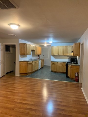 174 Jencks Street, Unit 3 Fall River, MA 02723 - Photo 4 of 5 a kitchen with stainless steel appliances wooden floors and view living room